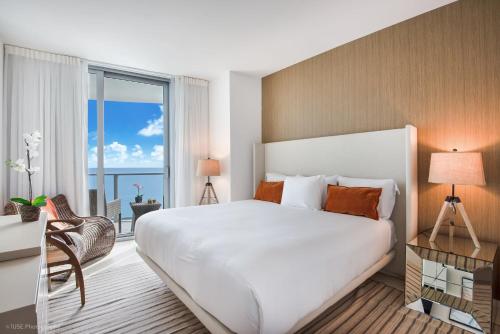 a bedroom with a large bed and a large window at Zen Vacation Rentals Ocean Front at Lyfe Resort in Hollywood