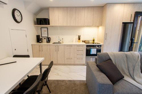 a kitchen and living room with a couch and a table at A touch of Luxury in Chch CBD in Christchurch