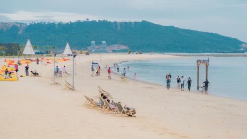 a group of people on a beach near the water at Summer Bay Beach Club & Cabins Sihanoukville by Preference in Sihanoukville