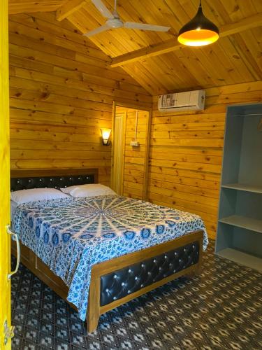 a bedroom with a bed in a wooden cabin at Chill Out Jasmine Restaurant Bar Rooms in Palolem