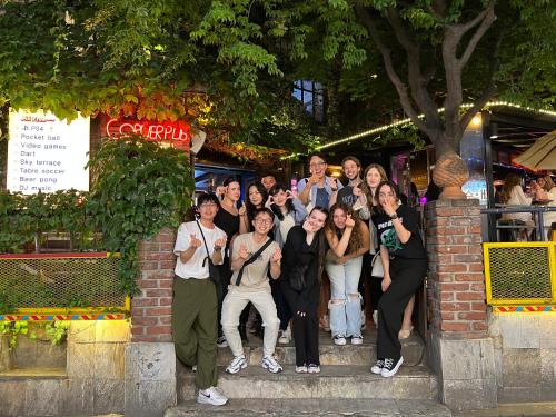 a group of people posing for a picture in front of a building at Hithere City Myeongdong in Seoul