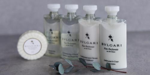a group of four bottles of moisturizers sitting on a counter at Alba HOTEL & Glamping in Nishinoura