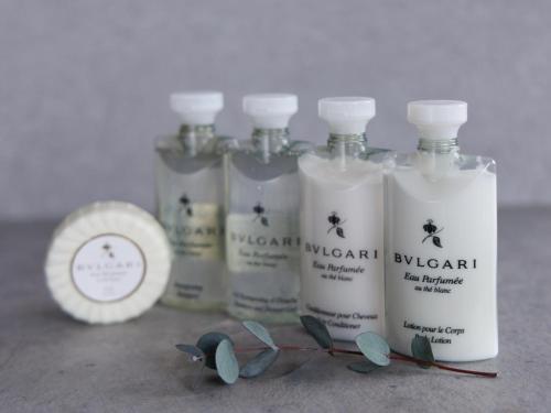 a group of four bottles of detergents on a counter at Alba HOTEL & Glamping in Nishinoura