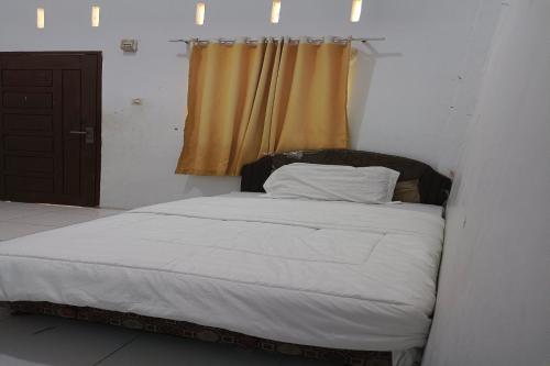 1 cama en una habitación con ventana en SPOT ON 93375 Elang Homestay, en Parit