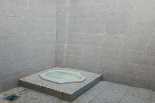 a bathroom with a toilet in a tiled room at Hotel O Elang Homestay in Parit