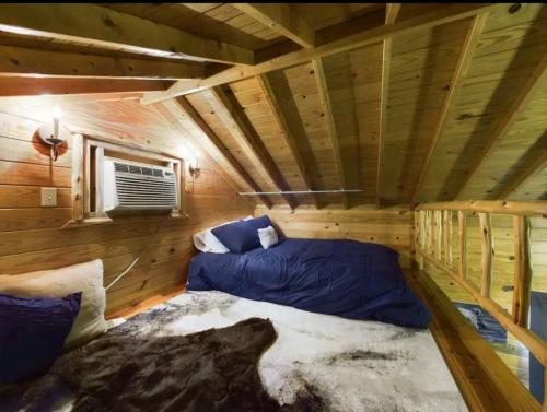 Habitación con cama en una cabaña de madera en Ultimate Escape and Wolf Den, en Lubbock