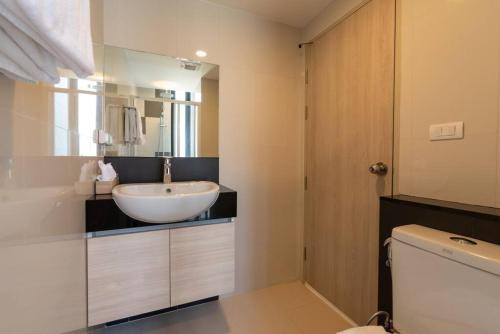 a bathroom with a white sink and a toilet at Modern Condo in Nimman (F806) by Pimolplace in Chiang Mai