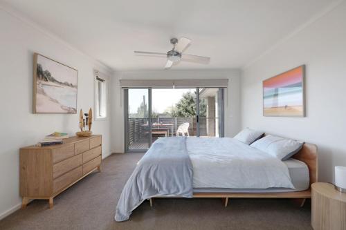 um quarto com uma cama, uma cómoda e uma varanda em Bayview Bliss em Surf Beach