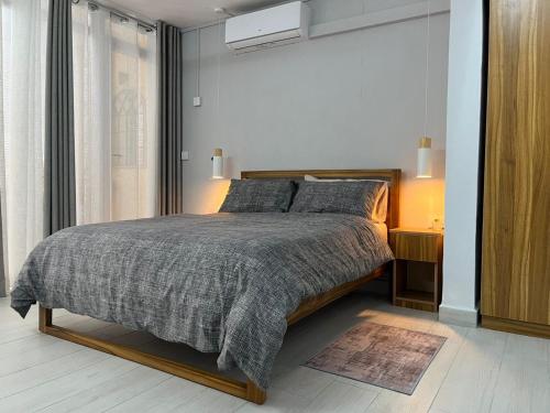 a bedroom with a bed with a gray comforter at Ebrahim Flats - Grand Baie Beach in Grand Baie