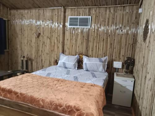 - une chambre avec un lit et un mur en bois dans l'établissement SHREYASH RESORTS, 