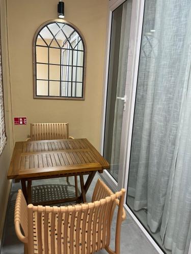 a table and chairs on a balcony with a window at Ebrahim Flats - Grand Baie Beach in Grand Baie