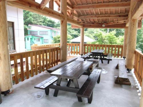 un pabellón de madera con mesas de picnic y bancos en una terraza en Cottage All Resort Service / Vacation STAY 8438 en Inawashiro