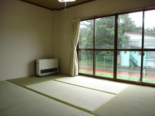 ein leeres Zimmer mit einem Fenster und einem TV in der Unterkunft Cottage All Resort Service / Vacation STAY 8438 in Inawashiro