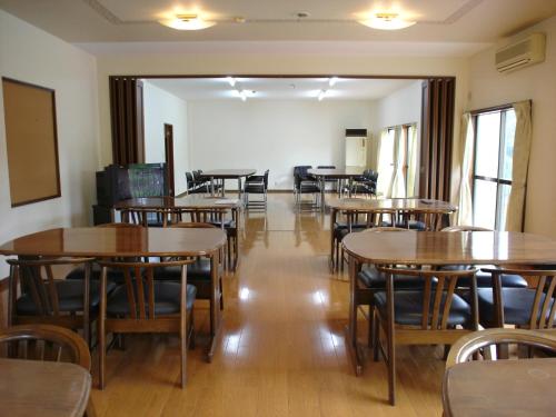 ein leeres Zimmer mit Tischen und Stühlen darin in der Unterkunft Cottage All Resort Service / Vacation STAY 8438 in Inawashiro