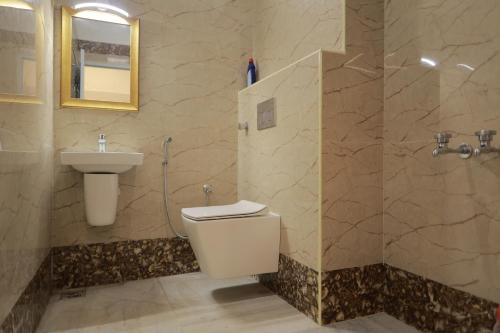 La salle de bains est pourvue de toilettes, d'un lavabo et d'une douche. dans l'établissement HOTEL CYRIL, à Kânyâkumârî
