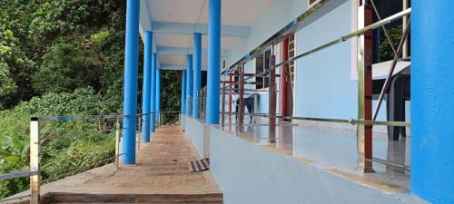 un bâtiment avec colonnes bleues et passerelle dans l'établissement Poornima Beach Stay, à Gokarna