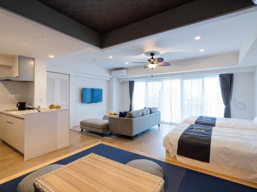 a bedroom with a king sized bed and a kitchen at Aqua Palace Chatan by Coldio Premium in Chatan