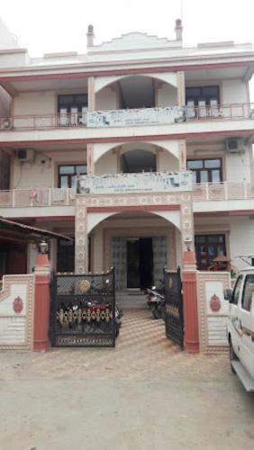 ein großes Gebäude mit einem Eingang mit einem Auto vor dem Haus in der Unterkunft Hotel Sai Krupa,Alirajpur 