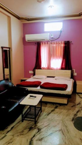 ein Schlafzimmer mit einem Bett, einem Sofa und einem Fenster in der Unterkunft Hotel Sai Krupa,Alirajpur 