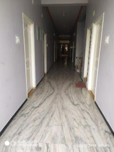 einen Flur mit Marmorboden in einem Gebäude in der Unterkunft Hotel Sai Krupa,Alirajpur 