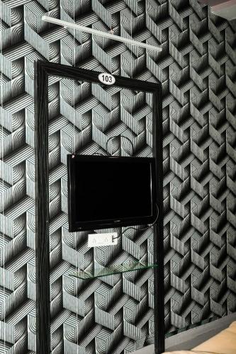 a wall with a tv on a wall with a pattern at HOTEL AL ZAM ZAM in Nagpur