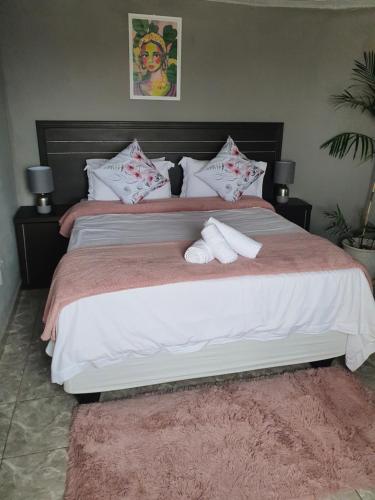 a bedroom with a large bed with two towels on it at Mpucuko Guest House in Mtubatuba