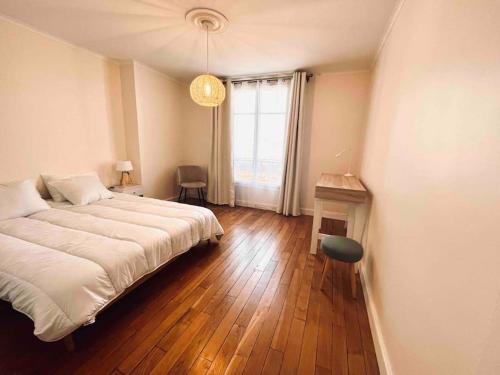 a bedroom with a large bed and a window at Appartement neuf, au calme, proche métro in Boulogne-Billancourt