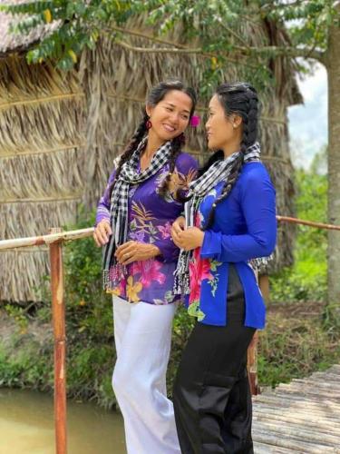 two women standing next to each other on a bridge at MEKONG DANIEL HOMESTAY CAN THO in Can Tho