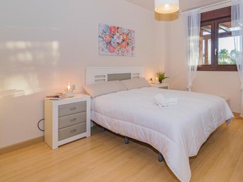 biała sypialnia z łóżkiem i stolikiem nocnym w obiekcie Playa Granada Motril Beach and Golf w mieście Motril