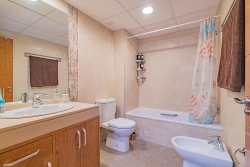 a bathroom with a sink and a toilet and a tub at Playa Granada Motril Beach and Golf in Motril