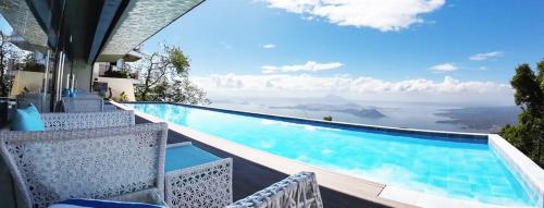 a pool with chairs and a view of the ocean at The Lake Hotel Tagaytay in Tagaytay