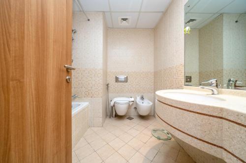 a bathroom with a tub and a toilet and a sink at ALH VAcay - Sulafa Tower - 1 Bedroom in Dubai
