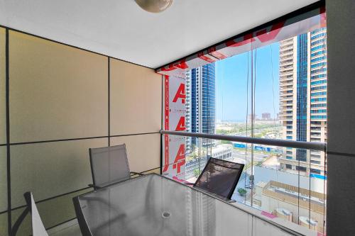 an office with a glass table and a large window at ALH VAcay - Sulafa Tower - 1 Bedroom in Dubai