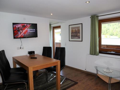 a dining room with a table and a tv on the wall at Apartment in Krimml with a balcony or terrace in Krimml