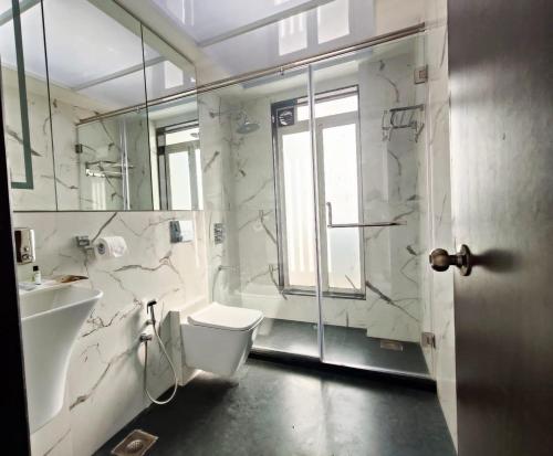 een badkamer met een toilet, een wastafel en een douche bij Premium Apartment in Hiranandani Powai by Maxxvalue - Chitranjan in Mumbai