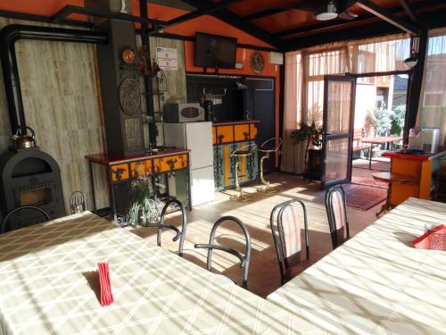 a room with a table and chairs and a stove at Apartments EMIZA in Samokov