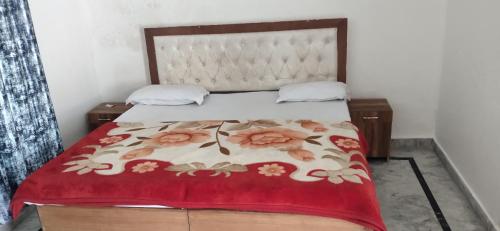 a bedroom with a bed with a red blanket at Govind Home Stay in Rishīkesh