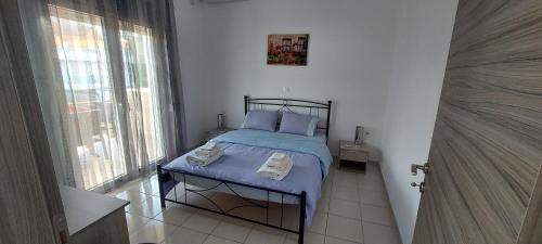 a bedroom with a bed with towels on it at Sun-n-Waves Holidaymakers in Rafina