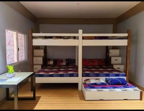 a bedroom with two bunk beds and a table at Ocean Myst Hotel & Beach Resort in Tambobong