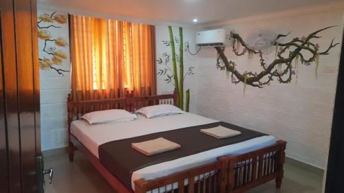 a bedroom with a bed with two towels on it at Samsara Harmony Beach Resort in Varkala