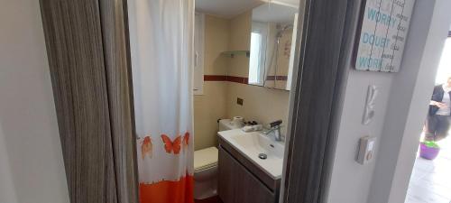 a bathroom with a sink and a shower curtain at Sun-n-Waves Holidaymakers in Rafina