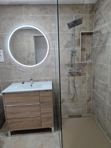 bagno con doccia, lavandino e specchio di Piso 110m² en el Palo con parking cerca de la playa a Málaga