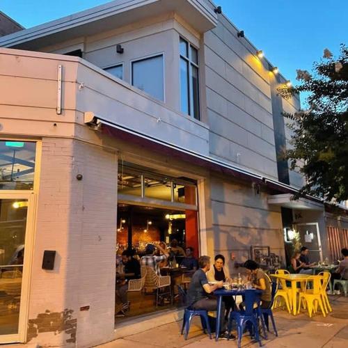 a group of people sitting at tables outside of a restaurant at Charming 2BD1BA in Hip Area - Near Metro in Washington
