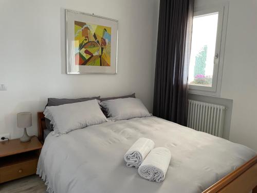 um quarto com uma cama branca e toalhas em BeB La Nociaia em Tavullia