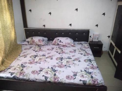 1 dormitorio con cama con colcha y almohadas de flores en Two bedroom Home at Gbagi, New Ife Road, Ibadan @ Igbekele Oluwa House, 3 Zone A, Opeyemi Street, New Gbagi Market, New Ife Road, Gbagi, Ibadan, Oyo State, en Ibadán