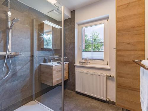La salle de bains est pourvue d'une douche et d'un lavabo. dans l'établissement Landhaus Central, à Söll