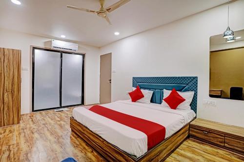 a bedroom with a large bed with red pillows at OYO Hotel Green Signature in Surat