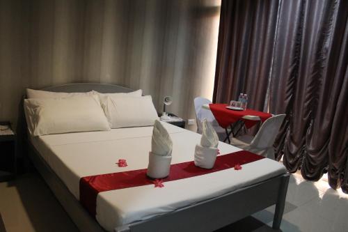 una camera d'albergo con letto e tavolo con coperta rossa di LORELEI BEACH RESORT a Gate