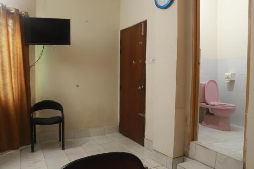 a room with a bathroom with a toilet and a television at Hotel Grand Amir International in Dhaka