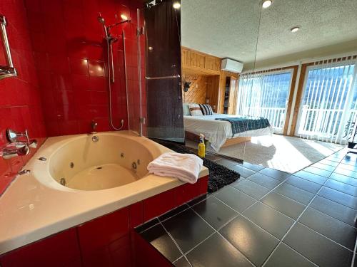 - une salle de bains rouge avec baignoire et une chambre dans l'établissement SPECTACULAR CATSKILLS 4 BEDROOM VACATION OASIS- Gorgeous Hunter Mountain Views!, à Hunter